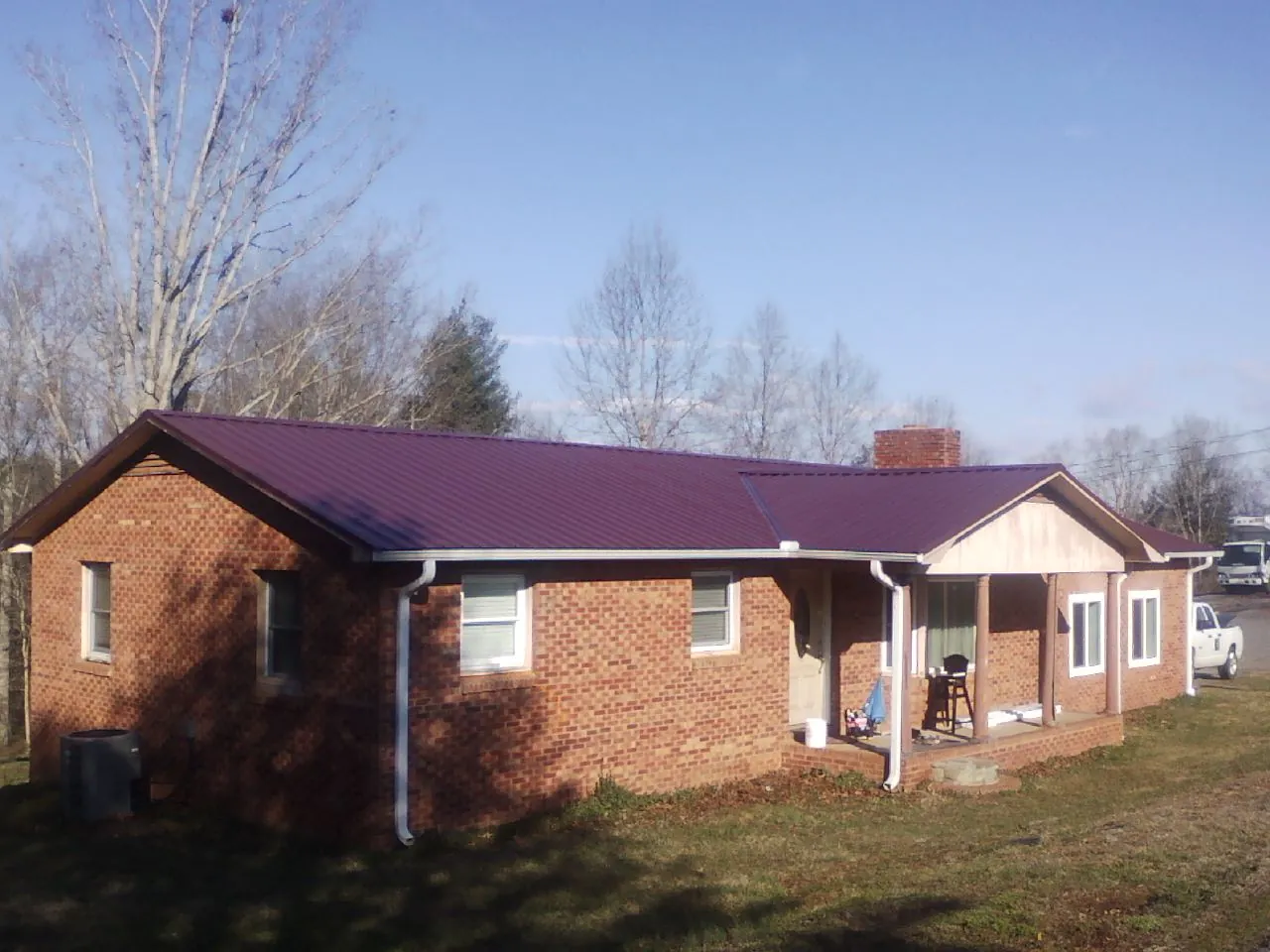 Burgundy metal roof on a brick ranch home with a new addition in Meadowview