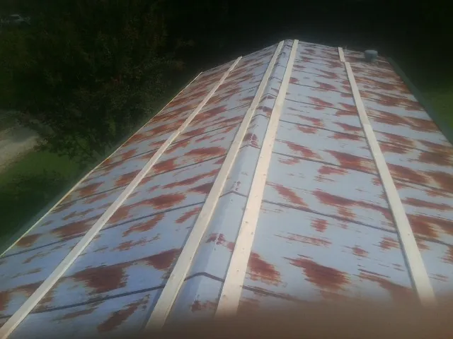 Rusted metal roof panels with new wood purlins before replacement — Storm Damage Roof Repair in Meadowview by Roofing Brothers