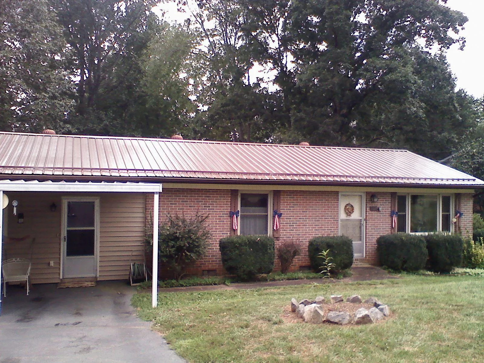 Bronze metal roof and carport on a brick ranch home — Roof Repair work by our crew in Meadowview
